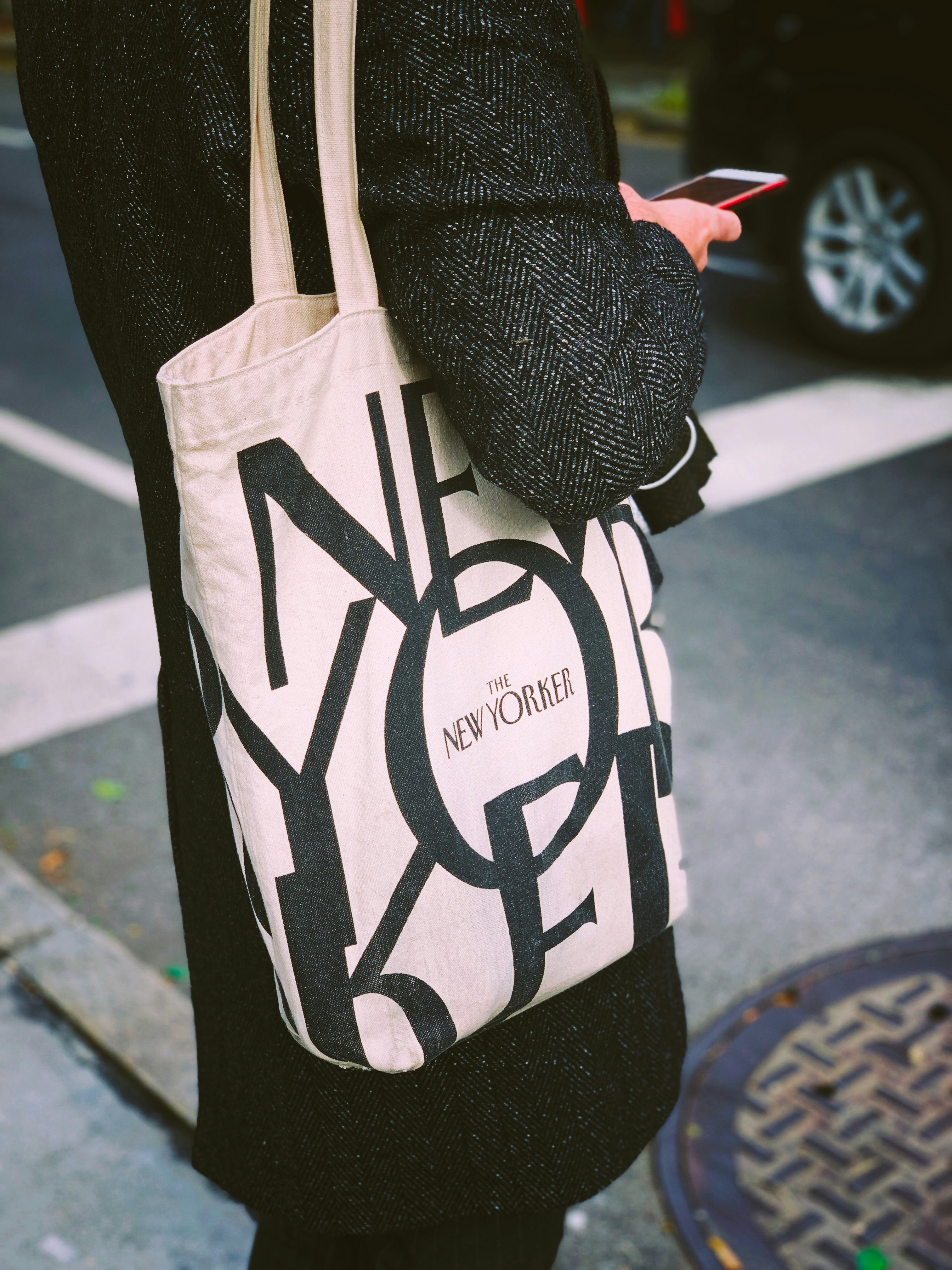 person carrying white and black tote bag